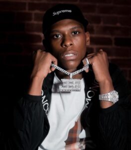 Headshot of a man holding his chain with huge locket