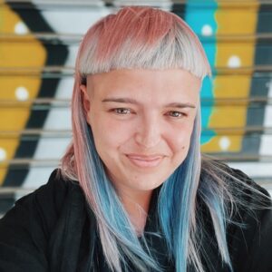 Headshot of a smiling woman with colored hair