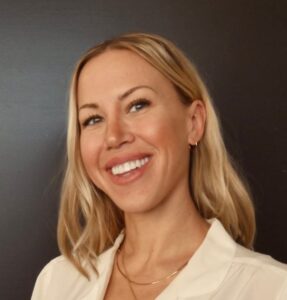 Headshot of smiling Shevy Smith wearing a white dress