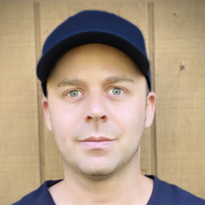 Headshot of a man wearing a blue cap