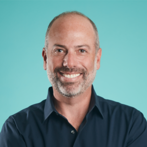 Headshot of a smiling man wearing a dark color shirt